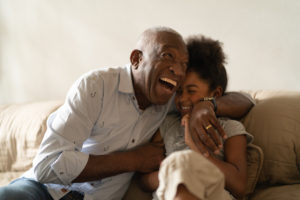 A grandfather hugs his granddaughter